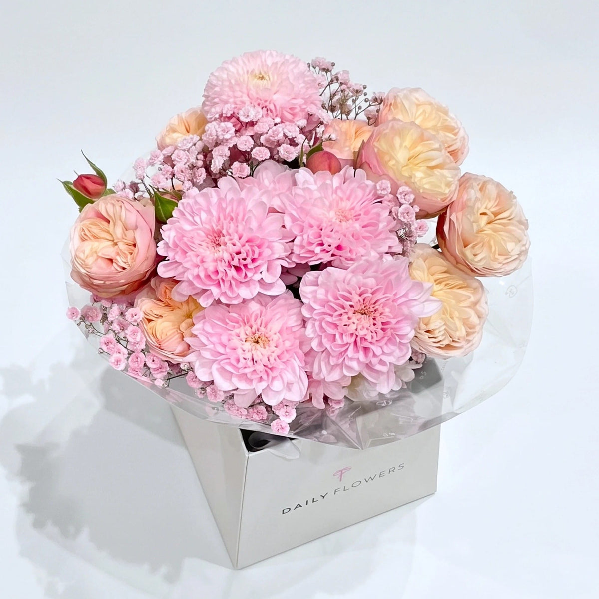 Baby Pink Blush Mini, Deluxe: small bouquet of baby pink chrysanthemums, peach garden roses and pink gypsophila in a Daily Flowers carrier