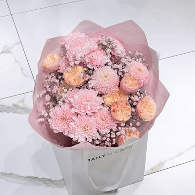 Baby Pink Blush bouquet, size Small: baby pink chrysanthemums, peach garden roses and blush gypsophila wrapped in pink paper, by Daily Flowers
